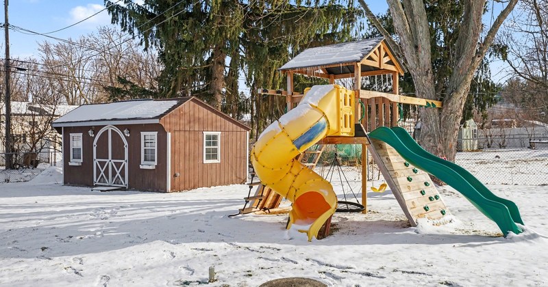 Un patio residencial nevado con cobertizo en invierno.