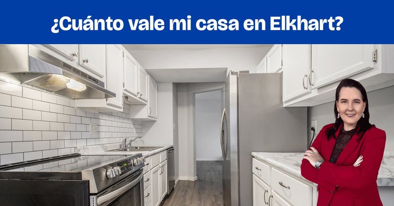 Una cocina con gabinetes blancos, azulejo tipo metro y electrodomésticos de acero inoxidable.