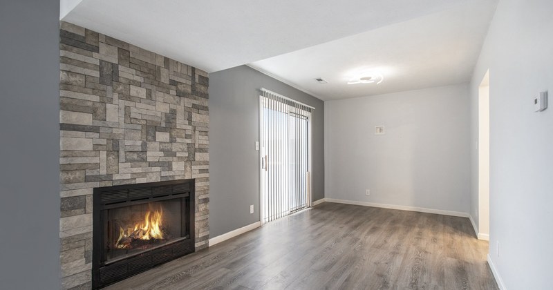 A living room with a stone fireplace wall.