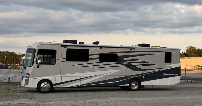 A motorhome parked on a lot at dusk, typical of the local RV industry.