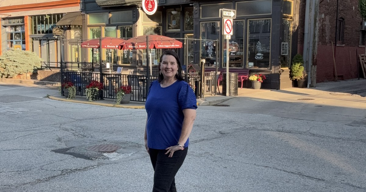 Lisa Collio on a downtown Goshen sidewalk outside a row of storefronts.
