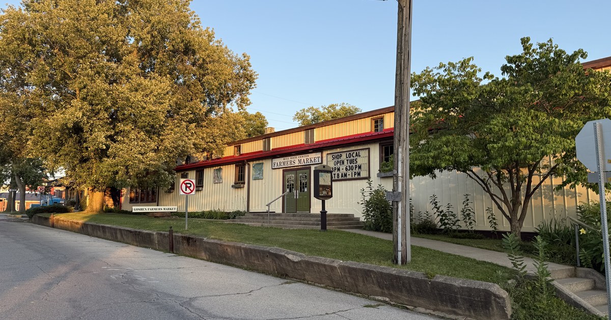 A low commercial building on a Goshen street lined with trees.
